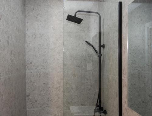 a shower with a glass door with a shower head at Casa Di Famiglia in Thessaloniki