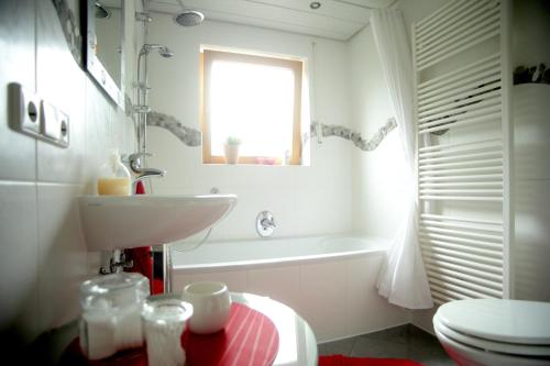 baño con lavabo y aseo y ventana en Ferienwohnung Schwarzwaldblick, en Bühlertal