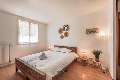 une chambre avec un grand lit avec des draps blancs dans l'établissement Family House in Disneyland BMYGUEST, à Serris