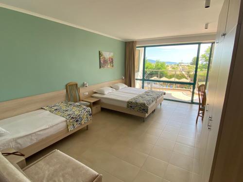 a bedroom with two beds and a large window at Sirena Hotel- ALL INCLUSIVE in Sunny Beach
