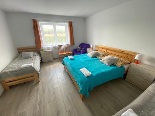 Un dormitorio con una gran cama azul y una ventana en Ubytování ve Starém Dvoře, en Třemošnice