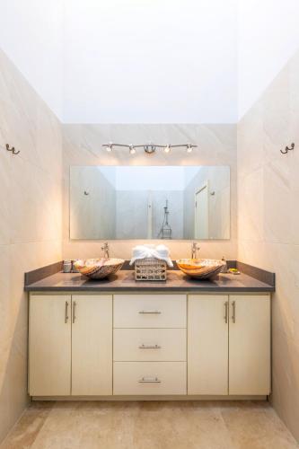 a bathroom with two sinks and a large mirror at VILLA ROA in Roatán