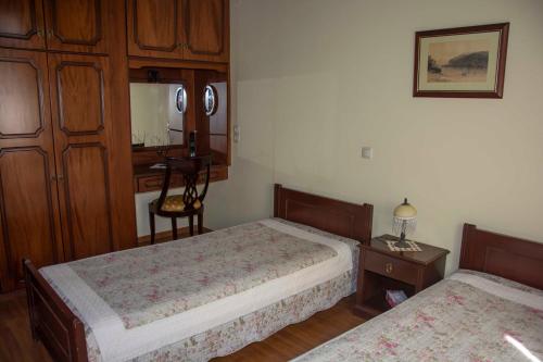 パレオカストリッツアにあるEmmy villa paleokastritsaのベッドルーム1室(ベッド2台、ランプ付きテーブル付)