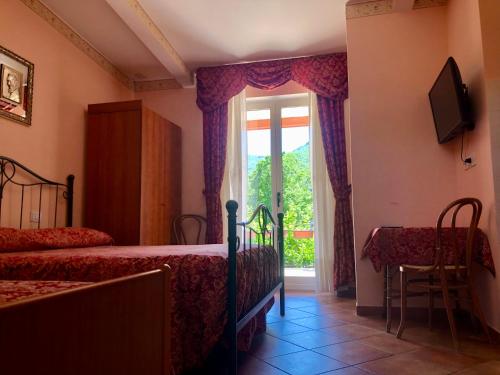 a bedroom with a bed and a window and a tv at Green Sunset in Tramonti