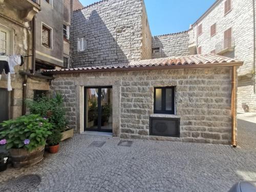 a stone house with a fireplace in a courtyard at Affittacamere Faber in Tempio Pausania
