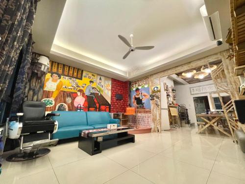 a living room with a blue couch and a ceiling fan at 安平72號民宿 in Tainan