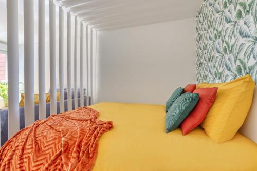 - une chambre avec un lit jaune et des oreillers dans l'établissement Grand studio Disney, queen size, coffee, WIFI, à Montévrain