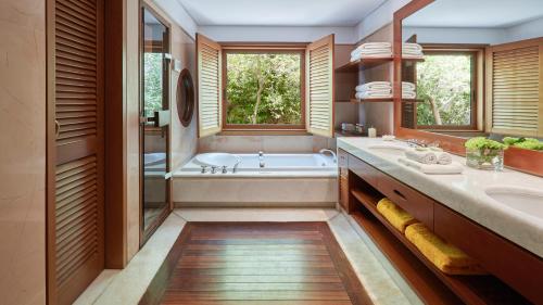 y baño con bañera y lavamanos. en Grand Resort Lagonissi en Lagonissi