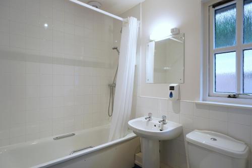 a bathroom with a sink and a toilet and a bath tub at Glenuig Inn in Lochailort