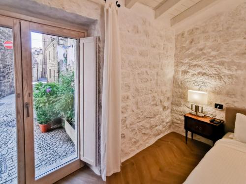 Zimmer mit einem Fenster, einem Bett und einem Tisch in der Unterkunft Affittacamere Faber in Tempio Pausania