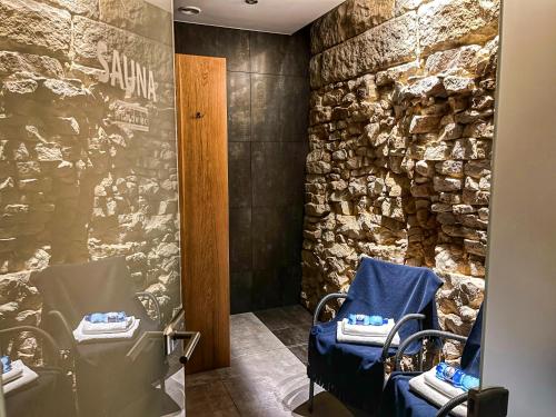 a room with two chairs and a stone wall at Villa Filmowiec in Polanica-Zdrój