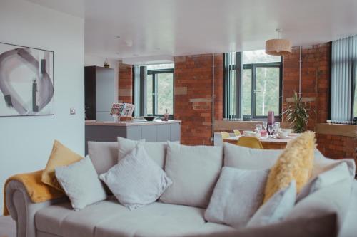 ein Wohnzimmer mit einer weißen Couch mit Kissen in der Unterkunft Bv Luxury Apartment Penthouse Conditioning House in Bradford