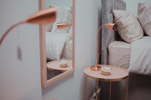 ein Spiegel und eine Lampe auf einem Tisch neben einem Bett in der Unterkunft Bv Luxury Apartment Penthouse Conditioning House in Bradford