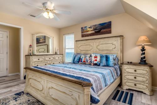 a bedroom with a large bed and a ceiling fan at The Boat House - 106 Westward Ho home in Dauphin Island