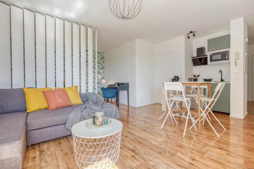 un salon avec un canapé et une table dans l'établissement Grand studio Disney, queen size, coffee, WIFI, à Montévrain