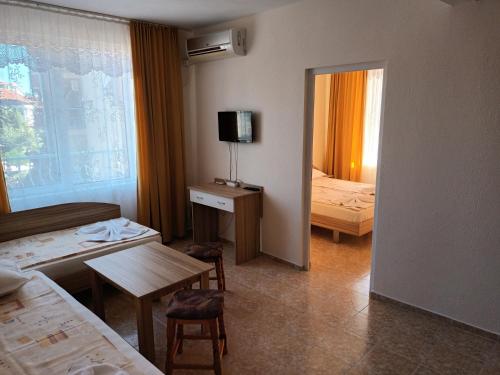 a hotel room with a bedroom with a bed and a mirror at Къща за гости Мишел in Nesebar