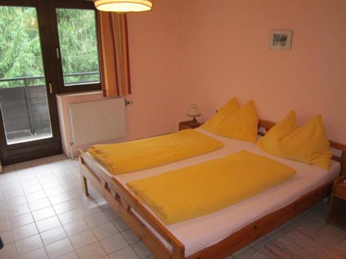 a bed with yellow sheets and pillows in a bedroom at Waldpension Stachl in Bromberg