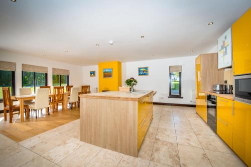 ビューリーにあるAchnagairn Estate - Self-catering Mini Manorsのオープンキッチン、ダイニングルーム(黄色のキャビネット付)