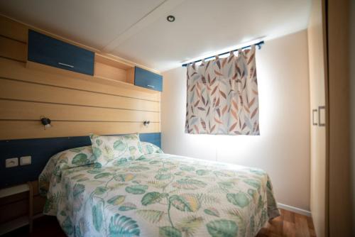 a small bedroom with a bed and a window at Remanso do Mar en O Grove in O Grove