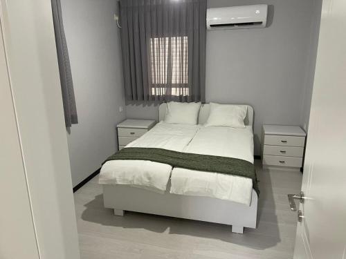ein Schlafzimmer mit einem weißen Bett und einem Fenster in der Unterkunft Menachem's Apartment in Bet Scheʼan