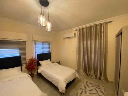 a bedroom with two beds and a window at Lovely 3-bedrooms rental unit in Aqaba