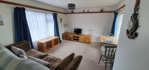 uma sala de estar com um sofá e uma televisão em Beautiful 1 bedroom cottage with courtyard. em Kent