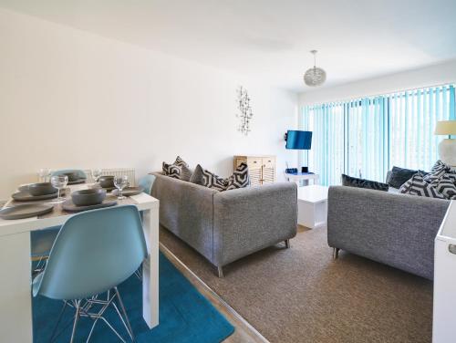 a living room with two couches and a table at Wheel Water Collections in St Austell