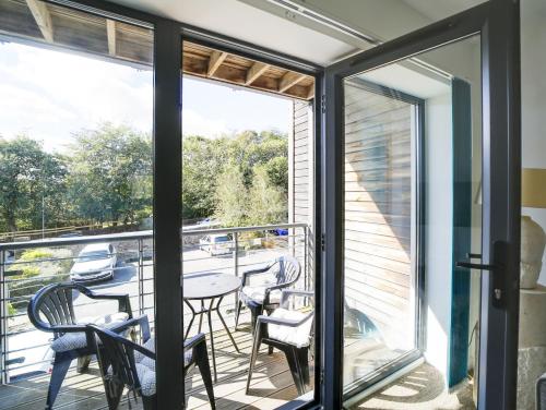a room with a balcony with a table and chairs at Wheel Water Collections in St Austell