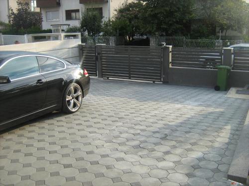 un coche aparcado en un estacionamiento junto a una valla en Apartman Maksimir with free parking en Zagreb
