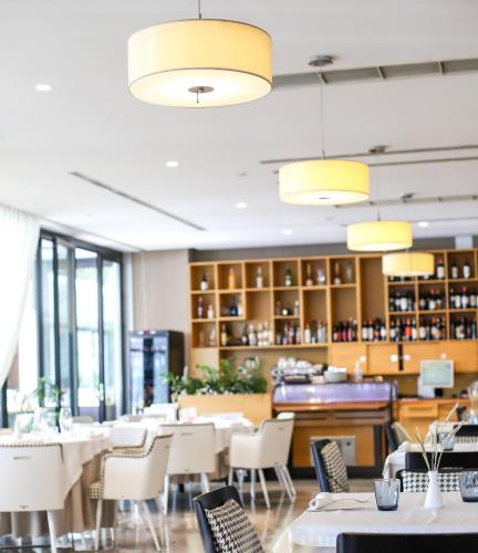 a restaurant with white tables and chairs and yellow lights at Best Western Premier Ark Hotel in Tirana