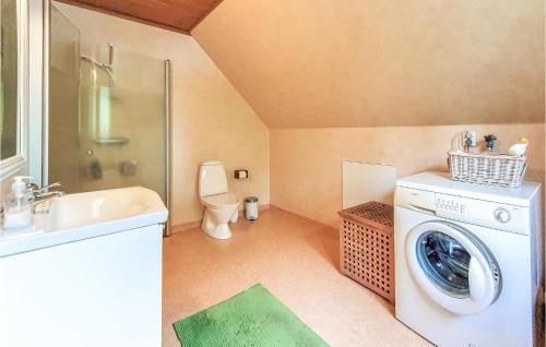 a bathroom with a washing machine and a toilet at Amazing Home In Örkelljunga With Sauna in Orkelljunga