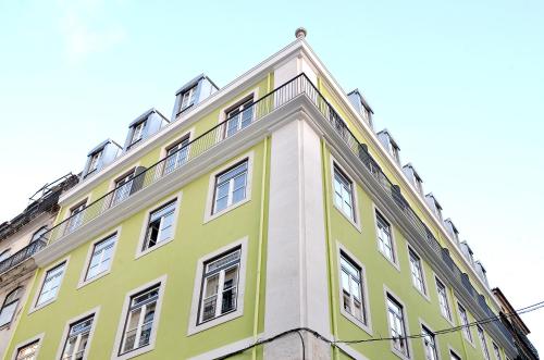 a yellow and white building with white windows at Browns Central Hotel in Lisbon