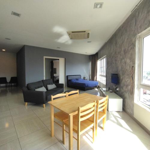 ein Wohnzimmer mit einem Tisch und einem Sofa in der Unterkunft Octagon Premium Ipoh Town Center 2BR 121 by Grab A Stay in Ipoh
