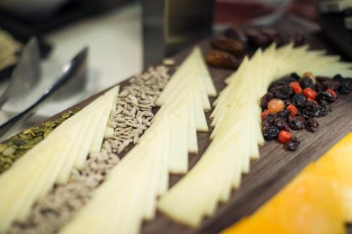 a cutting board with cheese and fruit on it at Petit Palace Triball in Madrid