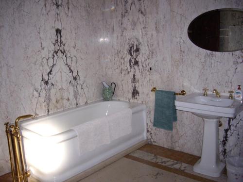 a bathroom with a white tub and a sink at Villa Benni B&B in Bologna