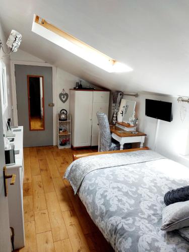 a bedroom with a bed and a desk with a computer at Broadlea of Robgill Country Cottage Accommodation in Ecclefechan