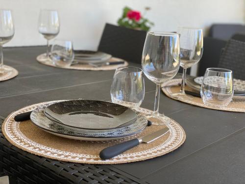 a table with plates and wine glasses on it at *** Domaine des Noyers - Proche centre Ville in Châteauneuf-sur-Loire