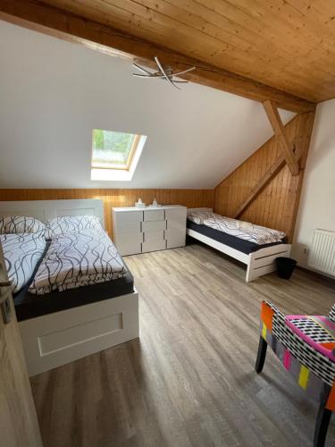 two beds in a room with wooden ceilings at Wellness pobyt v Pekle in Vrchlabí