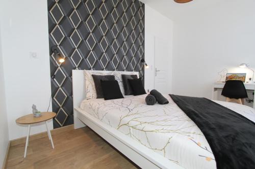 um quarto com uma cama e uma cabeceira em preto e branco em L'Urbain by EasyEscale em Romilly-sur-Seine