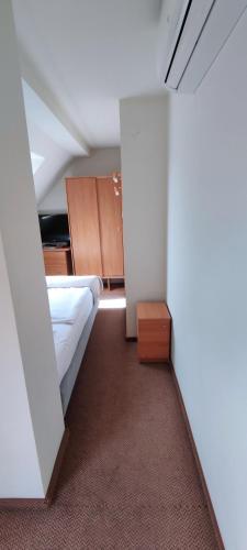 a small room with a bed and a closet at Hotel Kahlberg in Krynica Morska