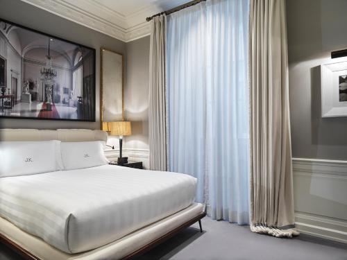 a bedroom with a white bed and a window at J.K. Place Roma - The Leading Hotels of the World in Rome