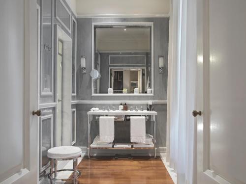a bathroom with a sink and a mirror and a stool at J.K. Place Roma - The Leading Hotels of the World in Rome