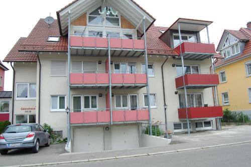 ラドルフツェル・アム・ボーデンゼーにあるGasthof Seeroseの通りに面した赤いバルコニー付きのアパートメントビル