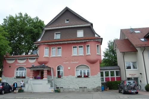 a large pink building with a brown roof at Gasthof Seerose in Radolfzell am Bodensee