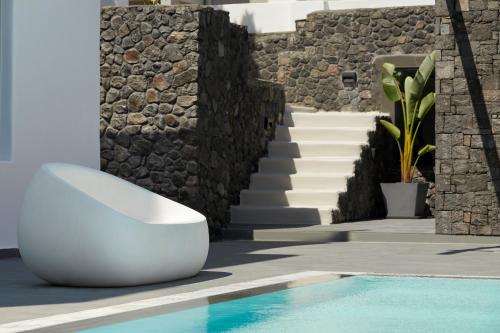 a white toilet sitting next to a stone wall at Kalisti Hotel & Suites in Fira