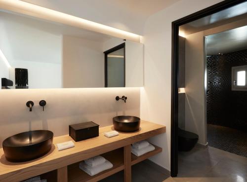 a bathroom with a sink and a mirror at Kalisti Hotel & Suites in Fira