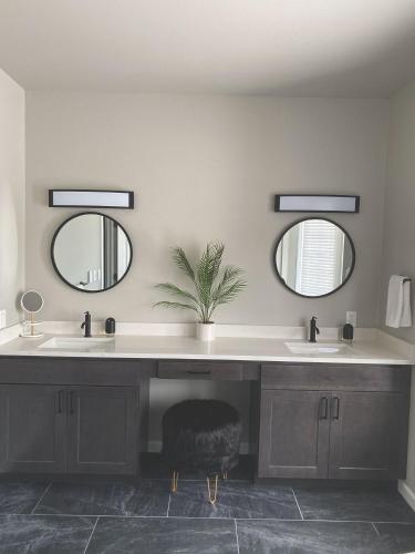 a bathroom with two sinks and two mirrors at Winter Park Chateau in Winter Park