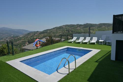 a person is standing next to a swimming pool at Casa da Costa Resende in Cárquere