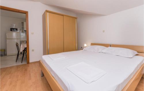 een slaapkamer met een groot wit bed en een keuken bij Cozy Apartment In Pakostane With Wifi in Pakoštane