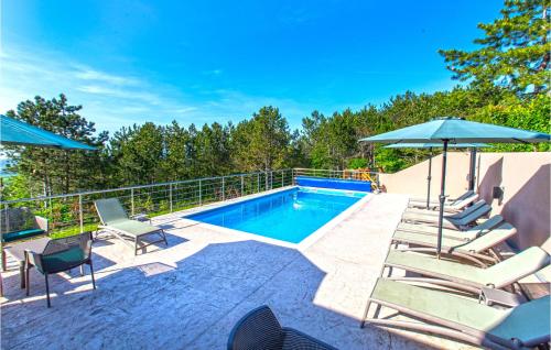 a swimming pool with lounge chairs and umbrellas next to at Amazing Home In Gracisce With Sauna in Gračišče
